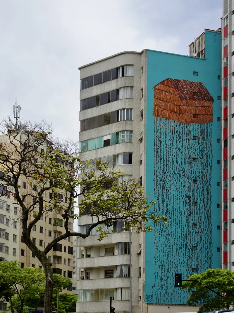 Tall and colorful mural of a house with long roots
